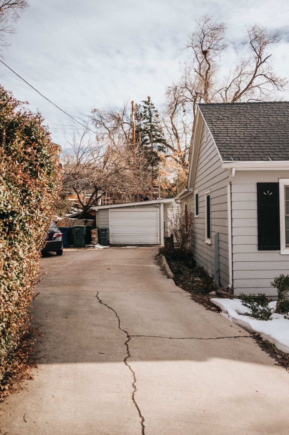 Concrete driveway with a long settlement crack running toward the house